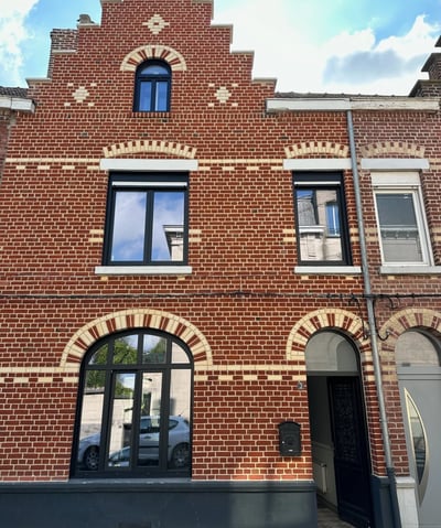 Maison en briques rouge avec fenêtres en aluminium noir
