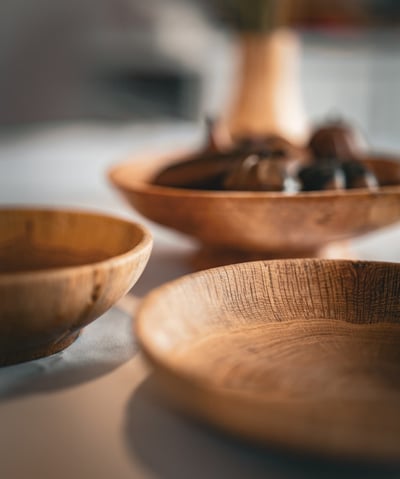 Composition artistique mettant en avant plusieurs bols et plats en bois faits main, posés sur une ta