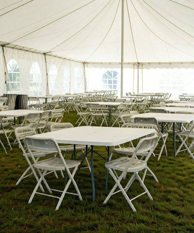tables and chairs under a tent