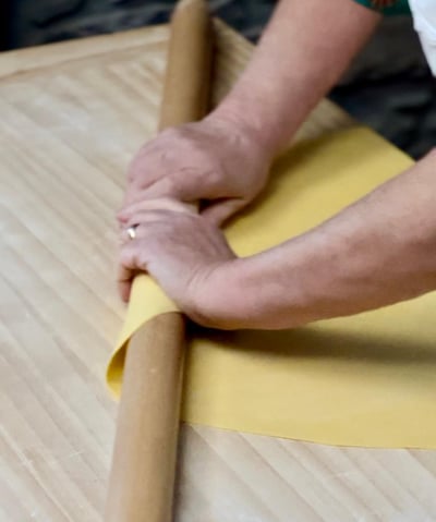 Close-up of Alessandra Spisni’s hands crafting handmade sfoglia, an Emilia-Romagna tradition.