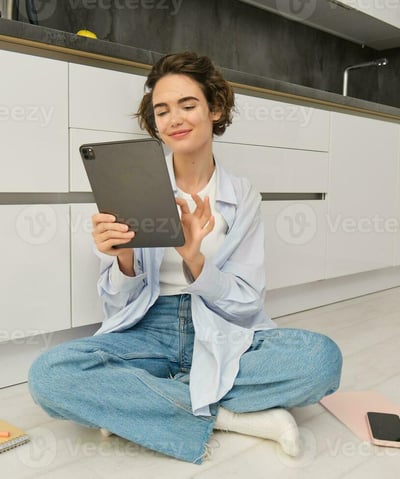 a woman sitting on the floor with a tablet computer and a tablet