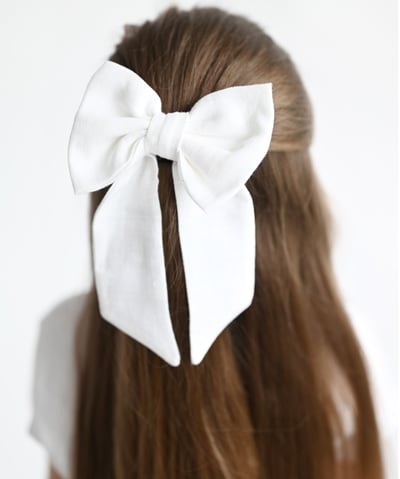 a woman with a white bow tie on her hair