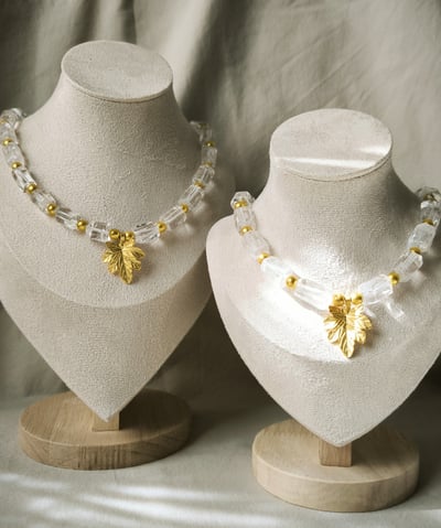 two necklaces with gold leaf charms on them