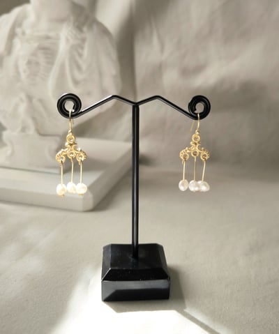 a pair of earrings with pearls and pearls