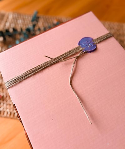 Elegant pink gift box sealed with a decorative wax stamp blue wax stamp, ideal for festive gifting