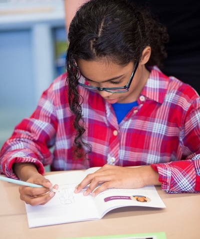 Elementary student reflects in a NaliniKIDS workbook.