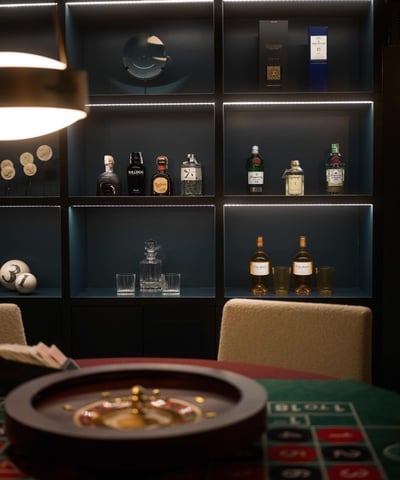 Bar shelf at Villa La Gratitud, with premium spirits, crystal glasses and roulette wheel.