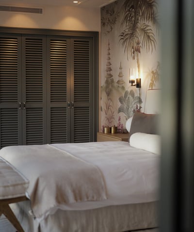 Elegant bedroom with Hamptons-style wardrobes, botanical mural, and soft neutral linens
