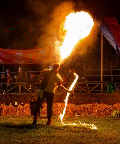 giocoliere che pratica l'arte dello sputafuoco