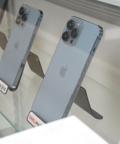 a display case with several different types of cell phones, computers and more