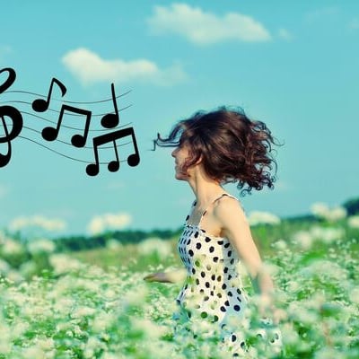 une femme épanouie dans un champs de fleurs qui chante