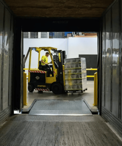 Forklift operator loading pallet into truck at warehouse — efficient delivery and logistics handling