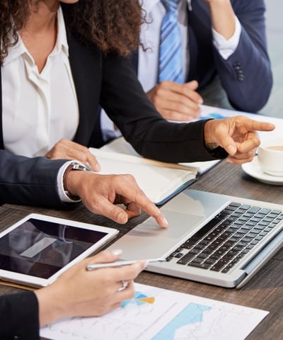 Pessoas em reunião frente a um notebook