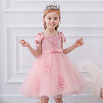 a pretty, smiling little girl wearing a pink party dress and a tiara