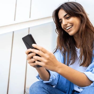 a woman sitting on steps with a cell phone