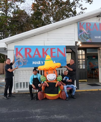 Miembros del equipo de Kraken Mar y Tierra frente a la entrada del restaurante en Fountain Inn