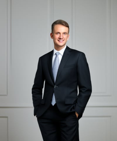a man in a suit and tie standing in front of a door