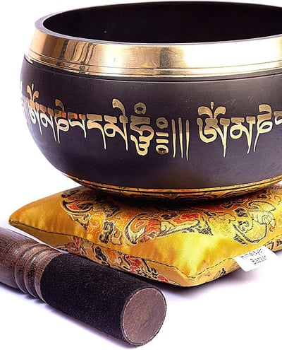 a singing himalayan bowl with a wooden stick 