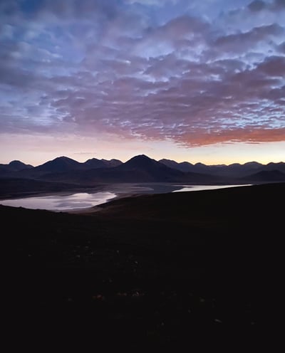 Sunrise during the ascent of Licancabur volcano, with warm light illuminating the rocky terrain.