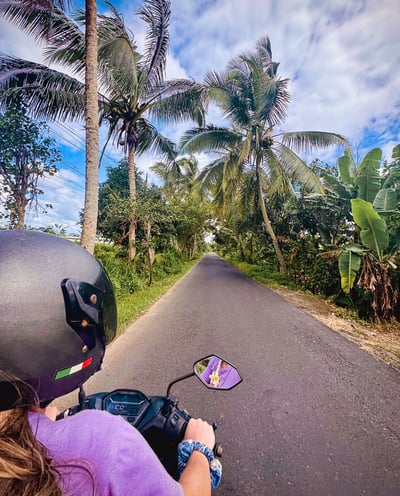 Photo of me riding a scooter along a scenic road in Nusa Lembongan.