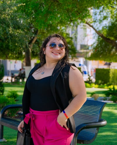 a woman in a black top and pink pants