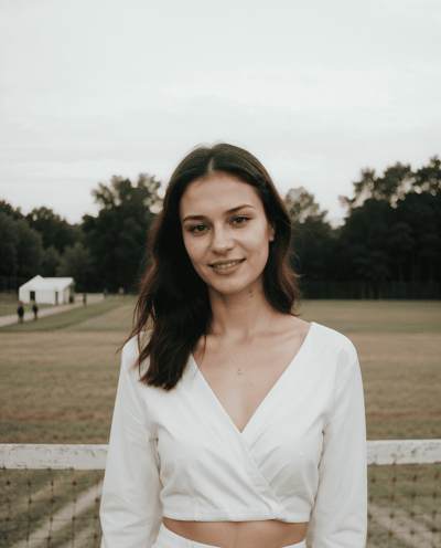 a woman in a white dress standing in front of a fence