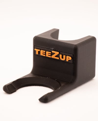 TeeZUP golf club attachment tee assist tool with orange wiriting on a white background