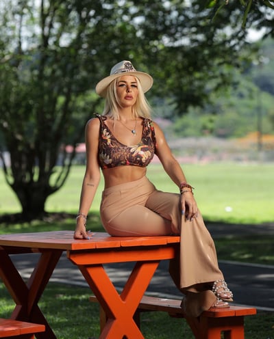 a woman in a bikini top sitting on a picnic table