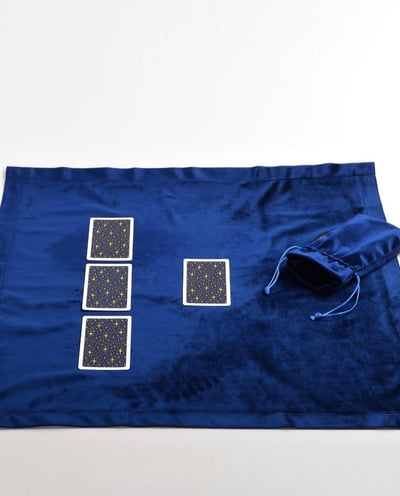 a blue cloth bag with four playing cards