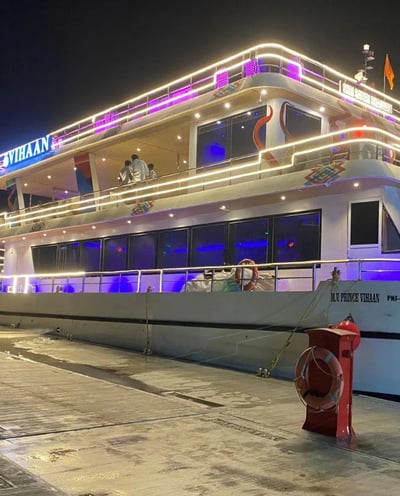 a boat docked at night with a boat in the background