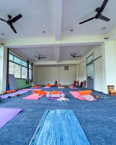 Yoga mats neatly arranged on the floor inside a bright and spacious training room, ready for a yoga class.