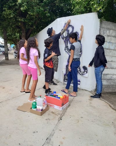 Grafite colaborativo – Adolescentes pintando em grupo na escola.