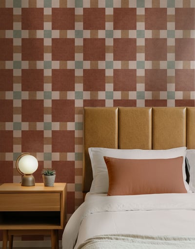 Terracotta and stone checkered wallpaper with a bold mid-century grid pattern, styled in a cozy bed