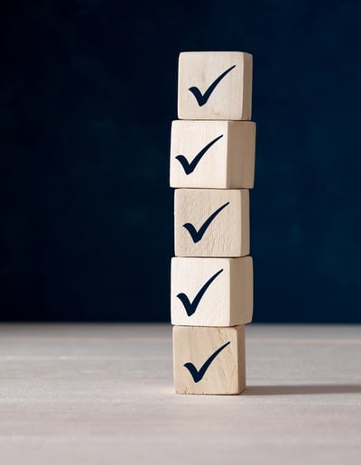 Stack of wooden blocks with black check/tick marks on them