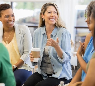 a group of people sitting around a table with coffee cups