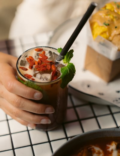 a person holding a drink in a glass