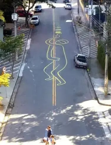 Intervenção Urbana: homem se segurando na faixa amarela da rua – Tec