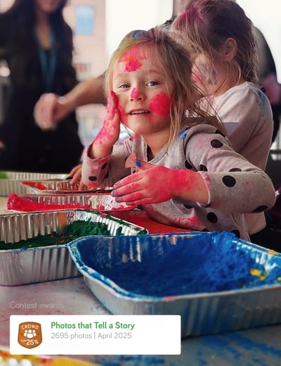 a young girl with her hands painted with red and blue paint holi