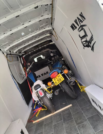 two motorbikes in the back of a van