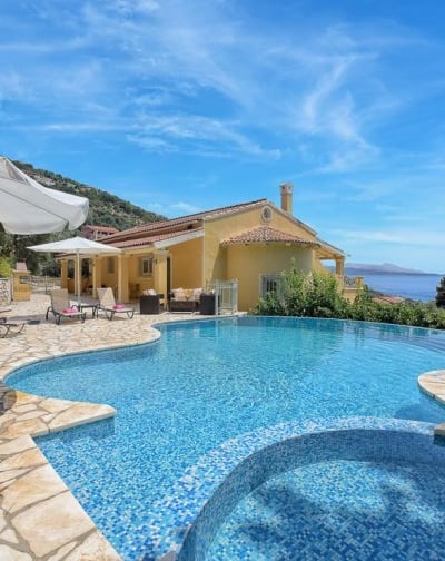 Private villa with private swimming pool with ocean and hills in the background