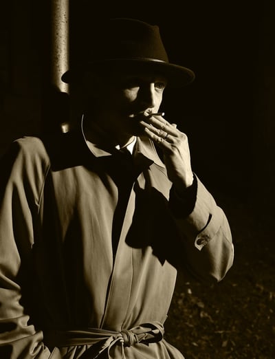 a man in a hat and rain jacket smoking