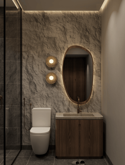 Modern bathroom with stone wall, floating wood vanity, oval mirror, and concealed ambient lighting.