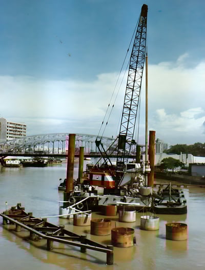 a crane crane is in the water near a dock