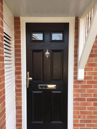 A black 4 panel 2 square door on ref bricks in black fitted in Gosport by Buildmydoor