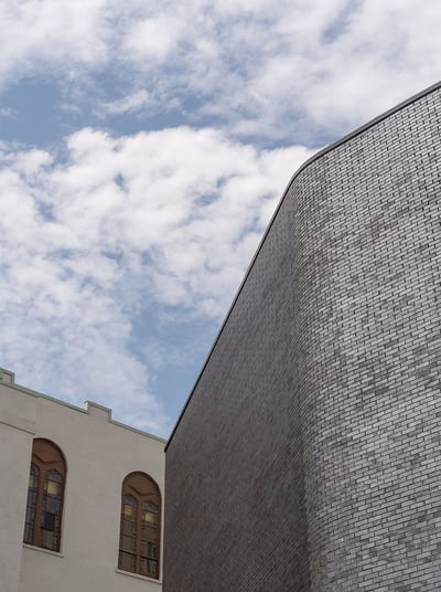 a brick clad building next to a white heritage building