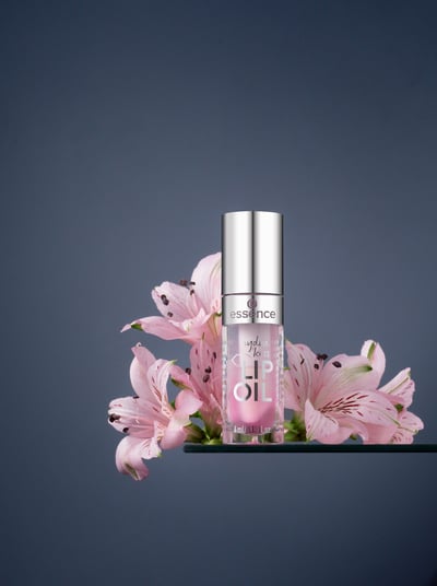 lip balm and flowers on grey background 