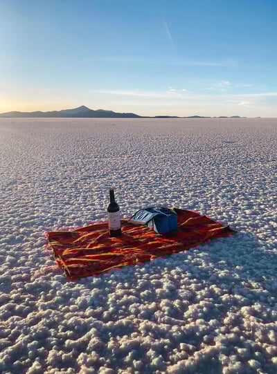 Bouteille de vin sur un plaid dans le Salar de Uyuni en Bolivie.