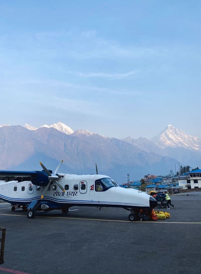 Plane on the runway at Lukla Airport, surrounded by the Himalayan mountains, Nepal.