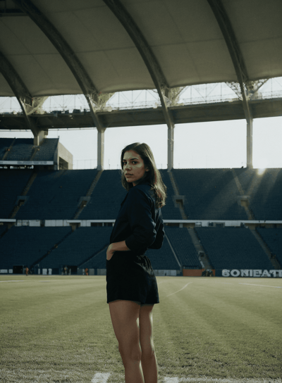 a woman in a black dress standing in a stadium