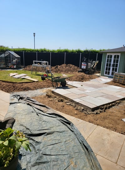 Sandstone paving being laid and flower beds being dug